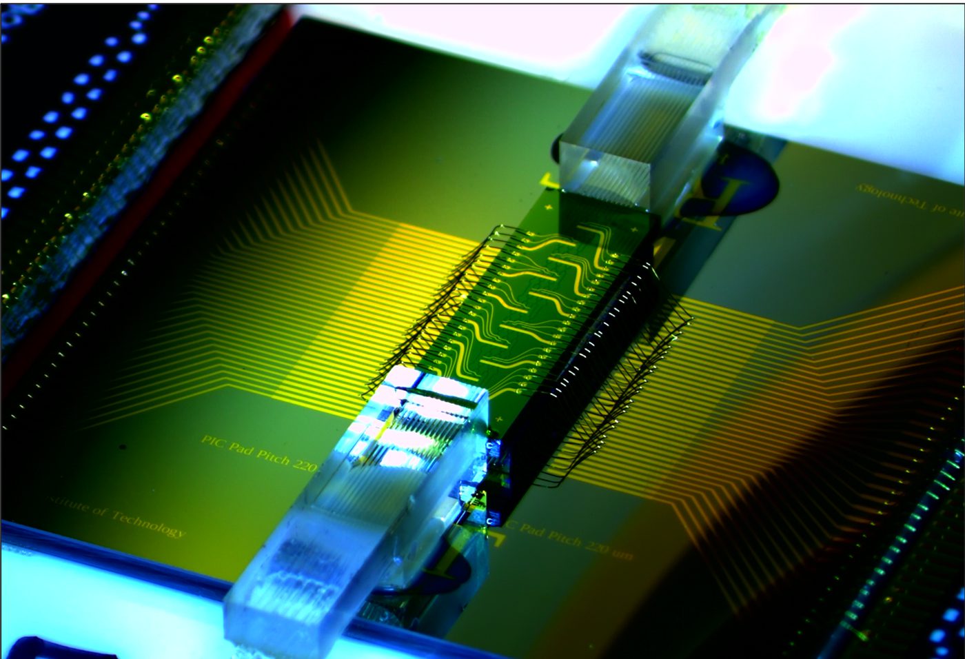Macro photograph of a packaged Noor-Q programmable photonic processor: wire-bonded silicon die between edge-coupled fiber arrays